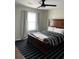 Cozy bedroom with a large dark wood bed, neutral walls, and stylish black striped rug at 117 Fripp Ln, Summerville, SC 29483