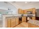 Open-concept kitchen features granite countertops, light wood cabinets, and a view to the living room at 122 Balsam Cir, Summerville, SC 29485