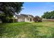 Large backyard with green grass, partial fence, mature trees, and patio at 123 Wheeler Rd, Summerville, SC 29486