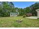 Landscaped backyard featuring a wooden deck, firepit, garden shed, and mature trees at 123 Wheeler Rd, Summerville, SC 29486