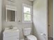 Cozy bathroom featuring a toilet, sink and mirror, and a window for natural light at 123 Wheeler Rd, Summerville, SC 29486