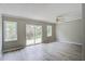 Living room showing gray walls and floors, ceiling fan, and sliding doors to the backyard at 123 Wheeler Rd, Summerville, SC 29486