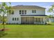 A spacious backyard features a screened porch and ample green space for outdoor activities at 1411 Homecoming Blvd, Ravenel, SC 29470