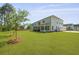 Serene backyard with a well-manicured lawn, screened-in porch, and mature trees for privacy and shade at 1411 Homecoming Blvd, Ravenel, SC 29470