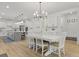 Open-concept dining area with stylish lighting, island seating, and modern cabinetry at 1411 Homecoming Blvd, Ravenel, SC 29470