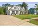 Well-manicured lawn and driveway lead to this charming two-story home with a welcoming front porch at 1411 Homecoming Blvd, Ravenel, SC 29470