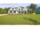Charming two-story home with a manicured lawn, light exterior, black shutters, and a welcoming front porch at 1411 Homecoming Blvd, Ravenel, SC 29470