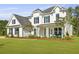 Charming two-story home with a welcoming front porch and well-manicured lawn, creating curb appeal at 1411 Homecoming Blvd, Ravenel, SC 29470