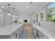 Open kitchen with large island, quartz countertops, farm sink, modern appliances and an open view to the living area at 1411 Homecoming Blvd, Ravenel, SC 29470