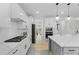 Bright open kitchen showcasing white cabinetry, stainless appliances, quartz countertops, and modern lighting at 1411 Homecoming Blvd, Ravenel, SC 29470