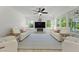 Inviting living room featuring comfortable seating, fireplace, large screen television and big windows at 1411 Homecoming Blvd, Ravenel, SC 29470