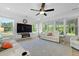 Bright living room featuring large windows, recliners, ceiling fan and tv over a fireplace at 1411 Homecoming Blvd, Ravenel, SC 29470