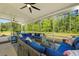 Screened-in patio with outdoor seating, ceiling fans, and tranquil backyard views at 1411 Homecoming Blvd, Ravenel, SC 29470