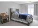 Neutral bedroom with dark wood bed frame, patterned bedding, and a window with gray curtains at 1485 Endicot Way, Mount Pleasant, SC 29466