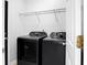 Clean laundry room with a black washer and dryer and wire shelving at 1485 Endicot Way, Mount Pleasant, SC 29466
