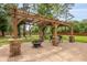 Outdoor patio featuring a pergola, stone pillars, dining table, and a fire pit at 1502 Southwick Dr, Johns Island, SC 29455