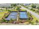 Scenic aerial view of two tennis courts surrounded by lush landscaping, water features, and neighborhood at 1505 Fort Palmetto Cir, Mount Pleasant, SC 29466