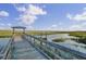 Picturesque view of a marsh with a wooden dock and a covered structure, under a bright sky at 1505 Fort Palmetto Cir, Mount Pleasant, SC 29466