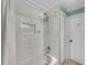 Elegant bathroom featuring a bathtub with a shower, white marble tile, and a convenient built-in niche for toiletries at 1522 Inland Ave, Charleston, SC 29412