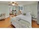 A serene bedroom with a white iron bed frame, complemented by wood floors, a ceiling fan, and mirrored closet doors at 1522 Inland Ave, Charleston, SC 29412