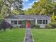 Charming home with a well-manicured lawn and vibrant red front door at 1522 Inland Ave, Charleston, SC 29412
