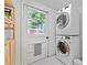 Well-lit laundry room features stacked washer/dryer and door to the outside at 1522 Inland Ave, Charleston, SC 29412