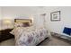 Bright bedroom featuring a floral bedspread, a dark wood nightstand and an open doorway to the ensuite bath at 153 Wild Holly Dr, Moncks Corner, SC 29461