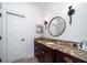 Classic bathroom featuring a marble countertop, dark wood cabinets, and a round mirror with custom lighting at 1531 Murphys Island Ct, Awendaw, SC 29429