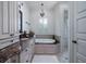 This bathroom features granite countertops, custom cabinets, a soaking tub, and elegant chandelier lighting at 1531 Murphys Island Ct, Awendaw, SC 29429