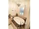 A luxurious bathroom features a soaking tub with marble surround and decorative accents under a chandelier lighting at 1531 Murphys Island Ct, Awendaw, SC 29429