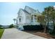 Elegant white home features a two-car garage, a charming balcony and bay window, plus lush landscaping with a view of the river at 1531 Murphys Island Ct, Awendaw, SC 29429