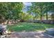Large backyard with mature trees, privacy fence, swing set and trampoline at 2010 Culver Ave, Charleston, SC 29407