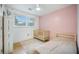 Bright Bedroom featuring pink accent wall, full sized bed, crib, and hardwood floors at 2010 Culver Ave, Charleston, SC 29407