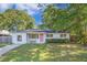 Charming white brick home with a well-manicured lawn and a bright pink front door at 2010 Culver Ave, Charleston, SC 29407