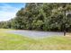Outdoor basketball court with hoops and marked lines, surrounded by trees and green grass at 2021 Arundel Pl, Mount Pleasant, SC 29464