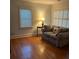 Cozy living room featuring hardwood floors, natural light from two windows, and a comfortable sofa at 2066 Maybank Hwy, James Island, SC 29412