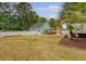 Spacious backyard with well-manicured lawn, garden beds, and a wooden pergola at 209 Forsythia Ave, Summerville, SC 29483