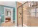 Bathroom shower area with tan tile and glass door, accented by blue walls in the room at 209 Forsythia Ave, Summerville, SC 29483