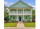 Inviting two-story home with double porches, lush landscaping, and a beautifully manicured lawn at 209 Forsythia Ave, Summerville, SC 29483