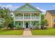 Welcoming two-story home with double porches, complemented by lush landscaping and a manicured lawn at 209 Forsythia Ave, Summerville, SC 29483