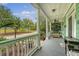 Inviting front porch features classic columns, a ceiling fan, and comfortable seating at 209 Forsythia Ave, Summerville, SC 29483