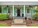Inviting front porch with columns, ceiling fans, and pineapple decor at 209 Forsythia Ave, Summerville, SC 29483