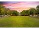 Expansive green lawn leading to a community building under a vibrant sunset at 209 Forsythia Ave, Summerville, SC 29483