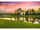 Scenic pond reflecting a vibrant sunset sky surrounded by lush greenery and trees at 209 Forsythia Ave, Summerville, SC 29483