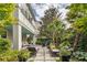 Lush backyard featuring chaise lounges, patio seating, vibrant greenery, and meticulously designed landscaping at 21 1/2 Pitt St, Charleston, SC 29401