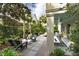 Spacious backyard patio with lush landscaping, seating, and privacy from the mature trees and manicured shrubs at 21 1/2 Pitt St, Charleston, SC 29401
