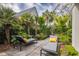 Private backyard lounge area with lush landscaping, stone pavers, and chaise lounges for outdoor relaxation at 21 1/2 Pitt St, Charleston, SC 29401
