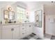Well-lit bathroom with dual sinks, white cabinets, granite countertops, and a large window for natural light at 21 1/2 Pitt St, Charleston, SC 29401