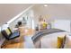 Sunlit bedroom boasts white walls, hardwood floors, a ceiling fan, and an adjacent sitting area with a desk at 21 1/2 Pitt St, Charleston, SC 29401