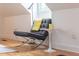 Modern accent chair and marble table are featured in this attic bedroom with hardwood floors and natural light at 21 1/2 Pitt St, Charleston, SC 29401
